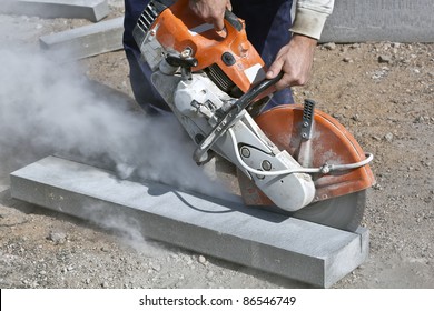 Construction worker cutting concrete curb