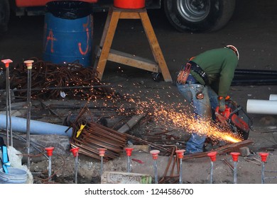 Construction Worker Cutting Steel Rebar With A Large Grinder For High Rise Building Downtown Apartment Hotel In Fort Lauderdale Florida. Near Miami, Broward, Tampa, Orlando, Boca Raton, Palm Beach.