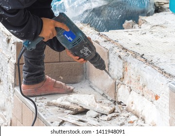 Construction worker destroying and repair floor by drill.The worker wear shoe unsafe may cause danger.
