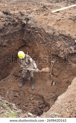 Construction worker digging a pit for the construction of a septic tank