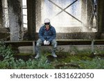Construction worker dressed in work clothes in a hard hat and gas welding glasses against the background of water splashes of the cooling unit.