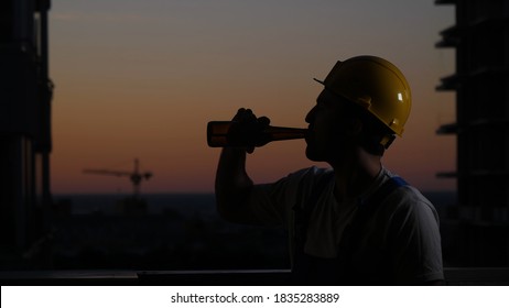 Construction Worker Drinking Beer In Helmet.