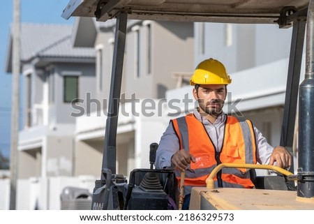 Construction worker are driving grader tractor or construction machine move the soil at the construction of housing estates.