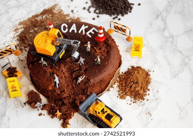 Construction worker figurines digging into chocolate cake        