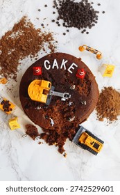 Construction worker figurines digging into chocolate cake                          