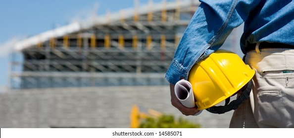 A construction worker or foreman at a construction site observing the progress of construction job or project, with copy space - Powered by Shutterstock