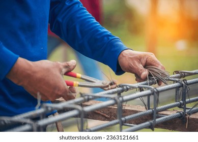 Construction Worker hands using pincer pliers iron wire. Outdoor Worker using wire bending pliers, construction work. Men hands bending cutting steel wire fences bar reinforcement of concrete work