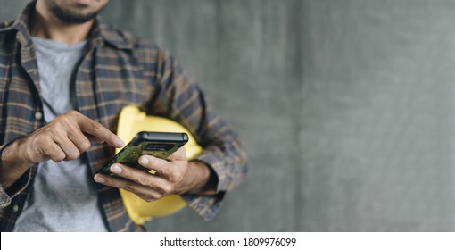construction worker hands using smartphone on cement wall background with copy space - Powered by Shutterstock