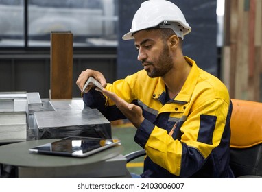 A construction worker in a hard hat is looking at a Stainless Steel Equal Leg Angles at a work site.