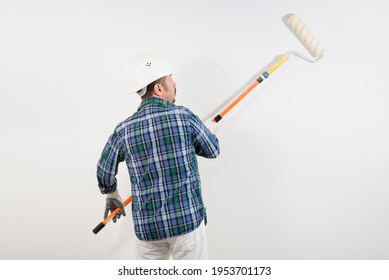 Construction Worker In Hard Hat Paints White Wall With Long Roller, Close-up Construction Mockup, Template