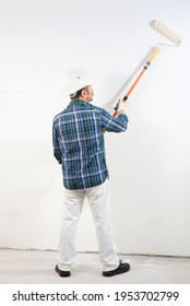 Construction Worker In Hard Hat Paints White Wall With Long Paint Roller, Construction Mockup,