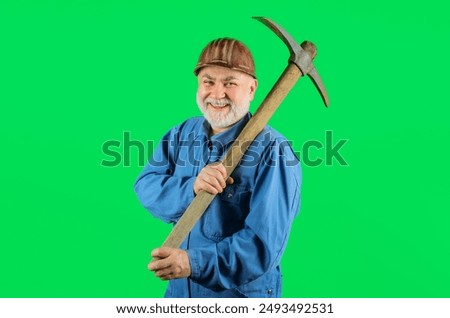 Construction worker in hard hat with pickaxe. Smiling builder man in uniform with pick-axe on shoulder. Mining industry. Mature coal miner with pickax. Male laborer with hand tool for digging, mining.