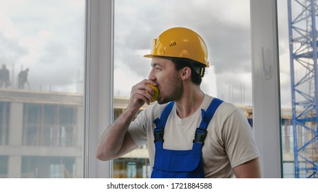 Construction Worker Having A Break And Eating Apple.