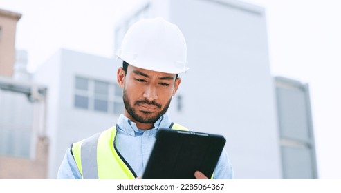 Construction worker holding a digital tablet while doing inspection. Organized male engineer or technician in a hardhat checking project plan with latest tech. Worker looking or overseeing operations - Powered by Shutterstock