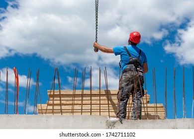 Construction Worker Holding A Metal Chain Looking At The Crane Operator Construction Site