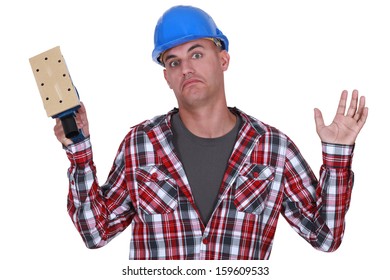 Construction worker holding up a sander