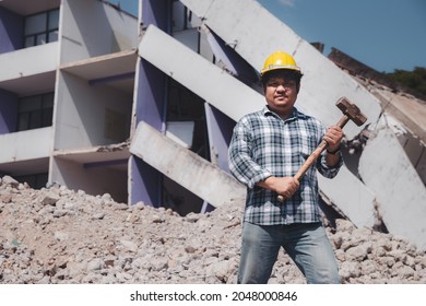 Construction Worker Holding A Sledge Hammer Standing On Demolish Building And Looking At The Camera. Earthquake. Industry.