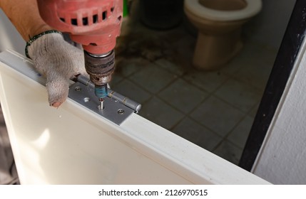 Construction Worker Installing A Bathroom Door