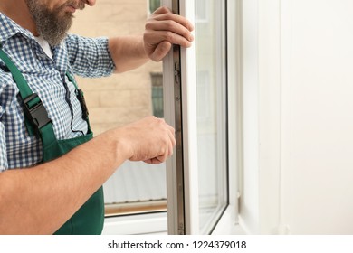 Construction worker installing new window in house