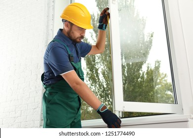 Construction Worker Installing New Window In House