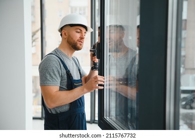 Construction worker installing window in house - Shutterstock ID 2115767732