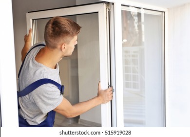 Construction Worker Installing Window In House