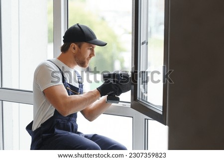 Construction worker installing window in house.
