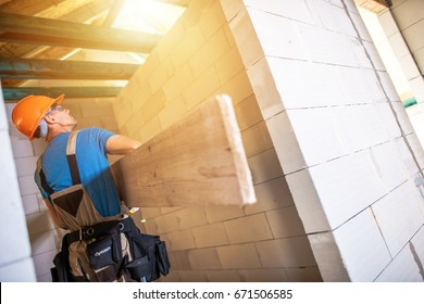 Construction Worker with Large Plank. House Building Project. Construction Business.