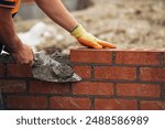 Construction Worker Laying Red Brick With Trowel and Mortar