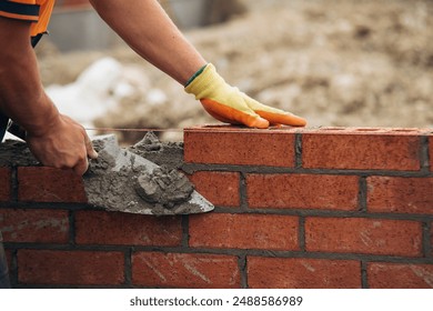 Construction Worker Laying Red Brick With Trowel and Mortar