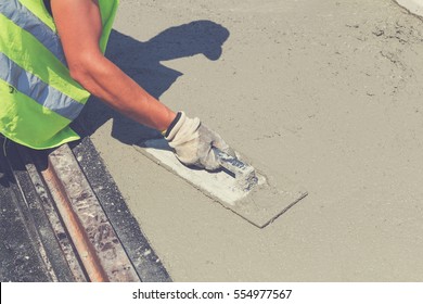 Construction Worker Leveling Concrete Pavement.