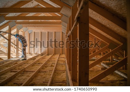 Construction Worker Looking Downstairs. Attic Wooden Roof Construction. House Cover. Wooden Structure.