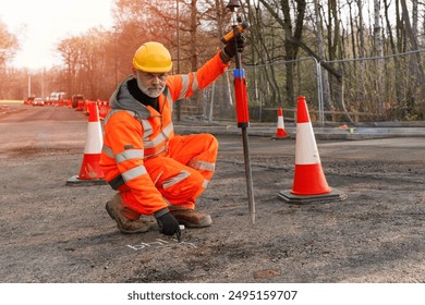 Construction Worker Marking Road Surface With Chalk in Daytime