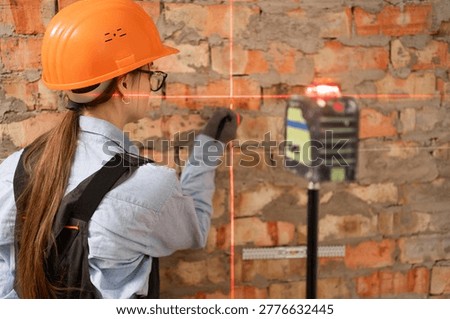construction worker marking wall using pencil and laser level during home renovation for control, measure and marking. copy space
