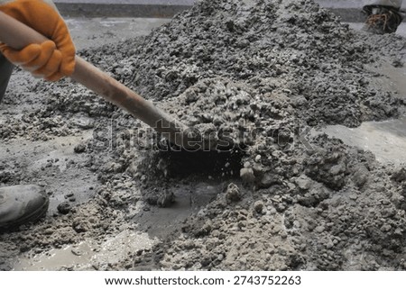 Construction worker mixes cement on a job site