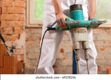 Construction Worker Mixing Concrete Or Grout With A Hand Mixer