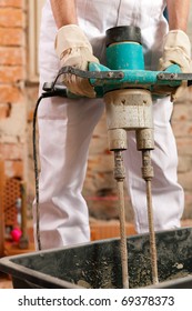 Construction Worker Mixing Concrete Or Grout With A Hand Mixer