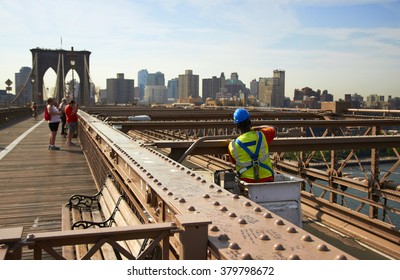 A Construction Worker On Brooklyn Bridge At Busy Sunny Day.