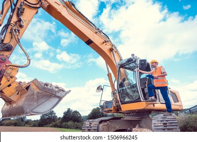 Construction Worker On Excavator Planning The Work To Be Done On The Site