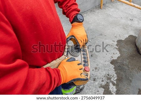 Construction worker operating remote control at building site