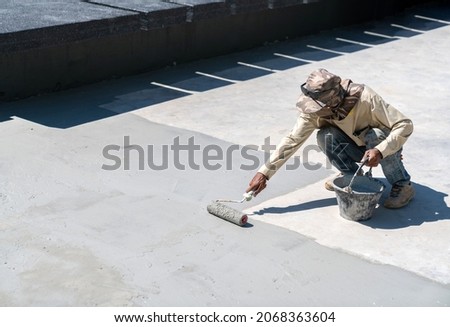 Construction worker paint water proof cement in pool protect water leak.