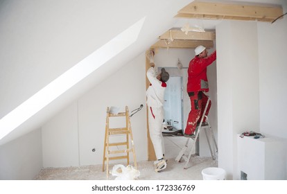 Construction Worker Is Painting The Wall In New House