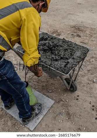 Construction worker performing concrete slump test at a construction site to check the consistency and workability of fresh cement mix.
