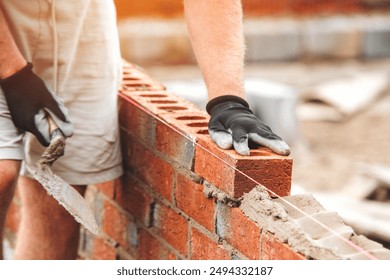 Construction Worker Placing Brick on Wall During Daylight Hours