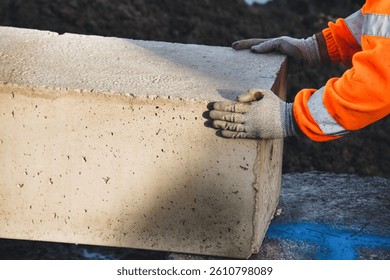 Construction worker placing heavy pre-cast concrete beam on building site