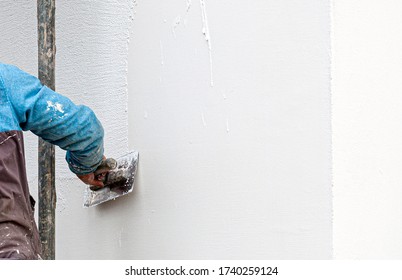 Construction Worker Plaster The Facade Of The House. Application Of Facade Plaster. Elevation Of The Building. 