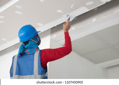 Construction worker plastering ceiling work