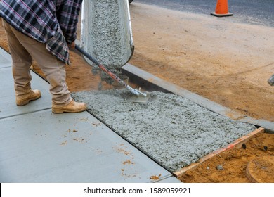 Construction Worker Pouring Reinforced Concrete Cement For Sidewalk In New Residential Home