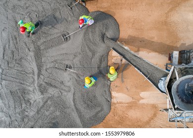A construction worker pouring a wet concret at road construction site
