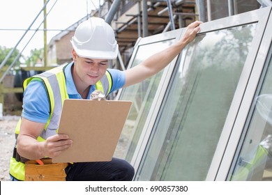 Construction Worker Preparing To Fit New Windows